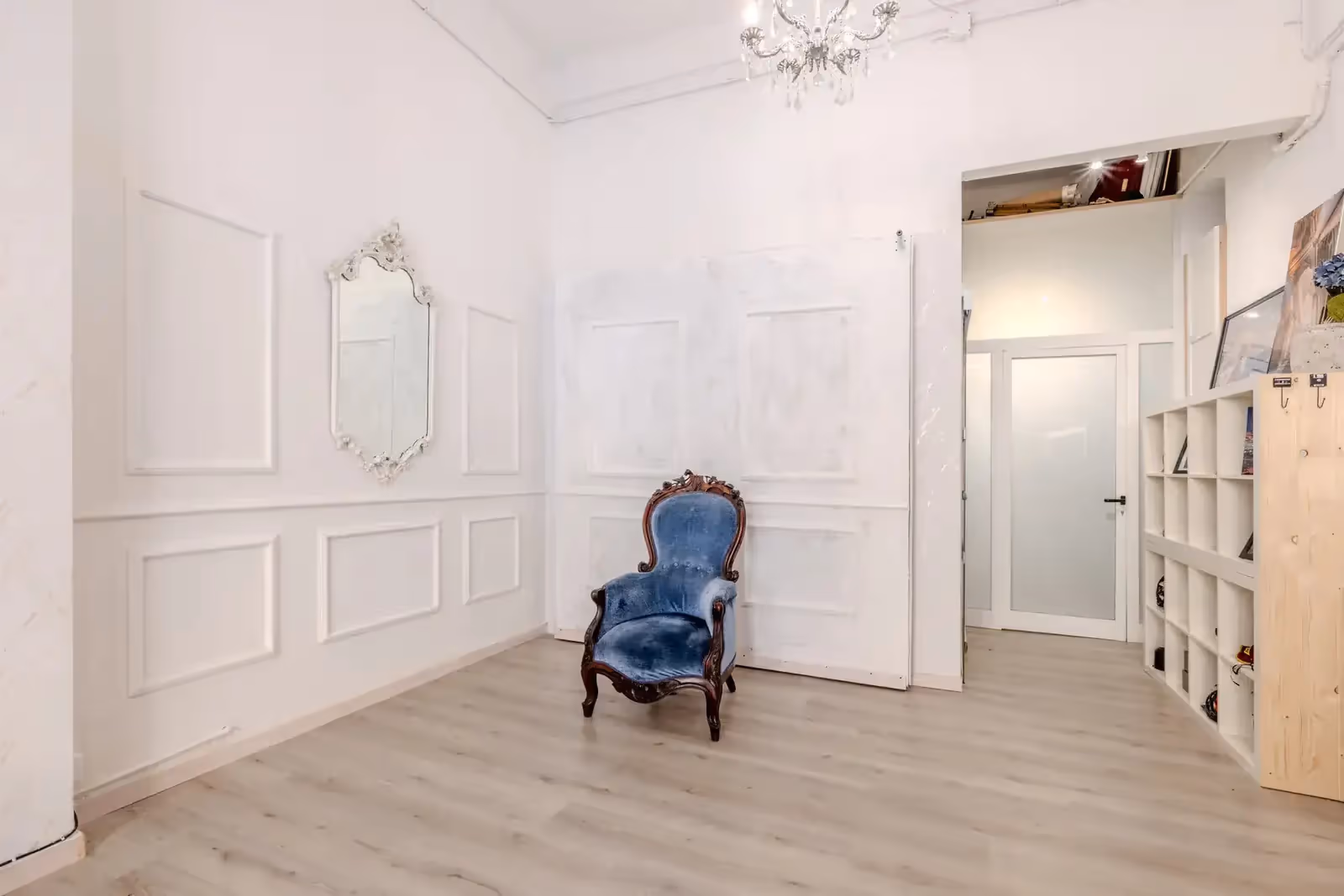 Interno elegante con poltrona blu e pareti decorate.