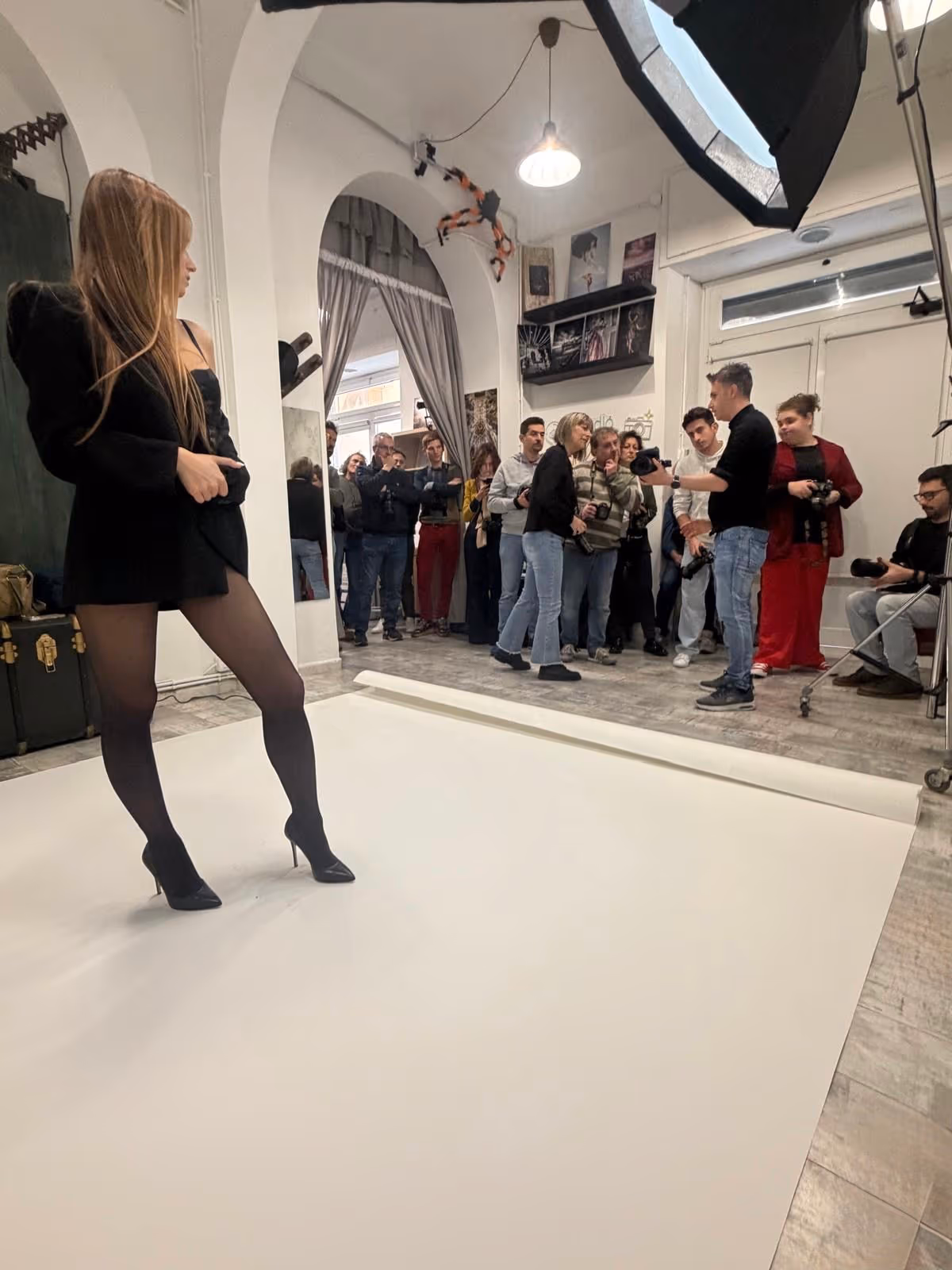 Modella sul fondale mentre il gruppo osserva il set