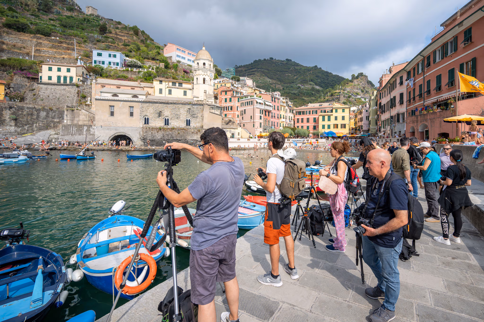 Fotografi al lavoro sul lungomare di un borgo ligure
