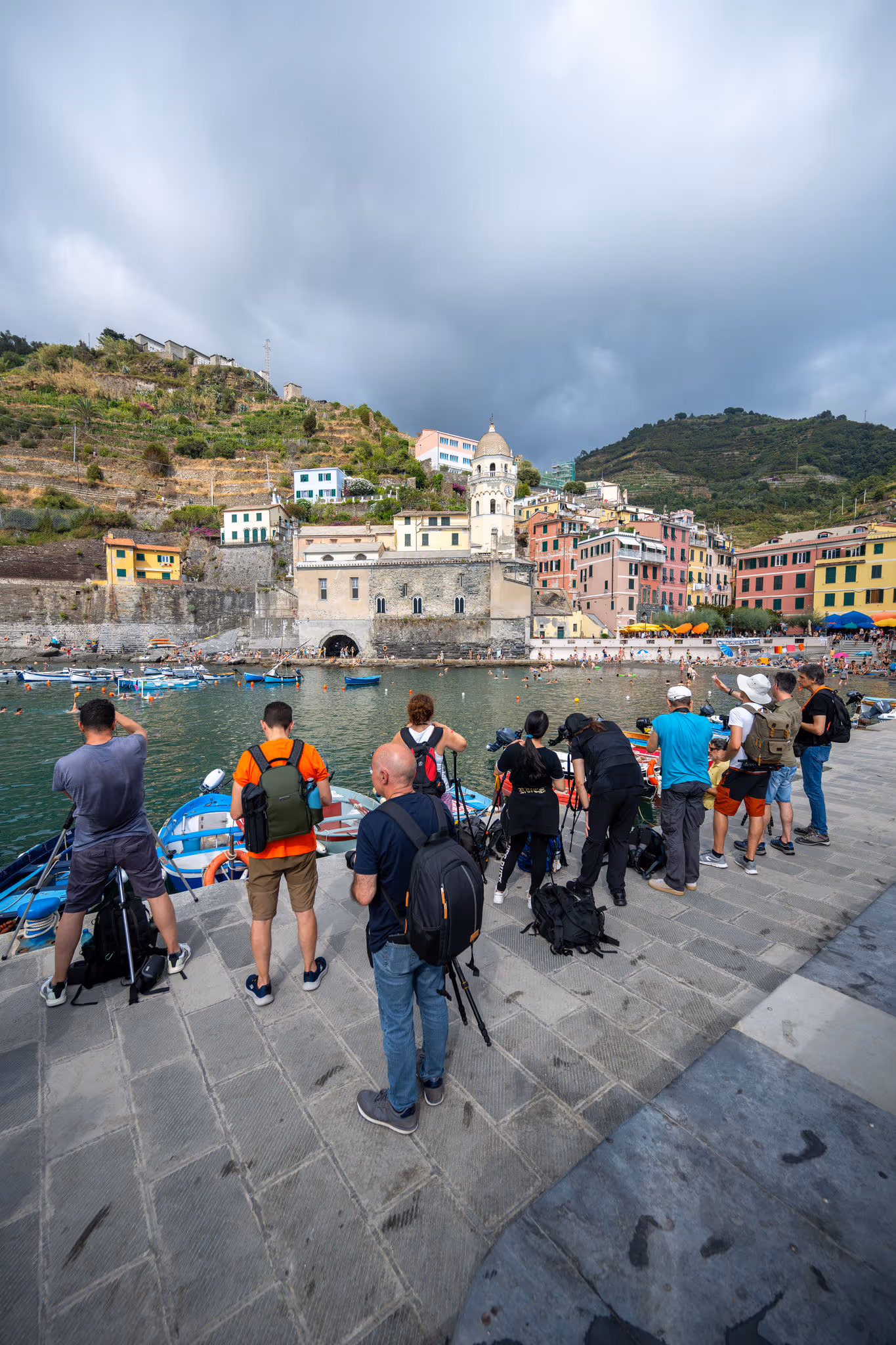Gruppo di fotografi davanti al porto e alle colline