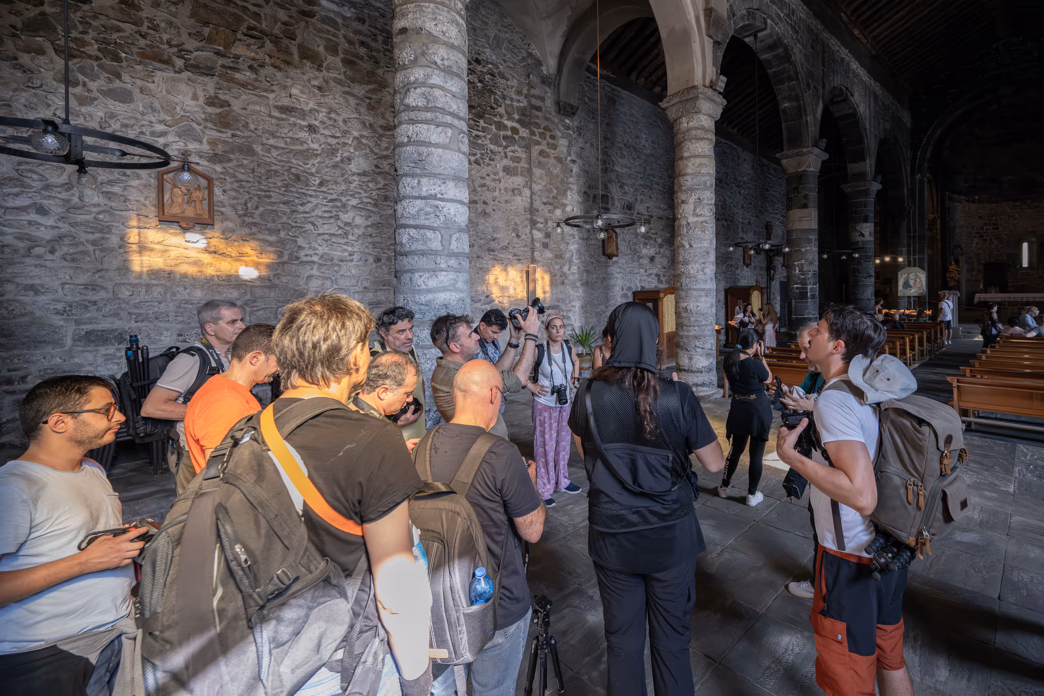 Partecipanti raccolti nella navata di una chiesa in pietra