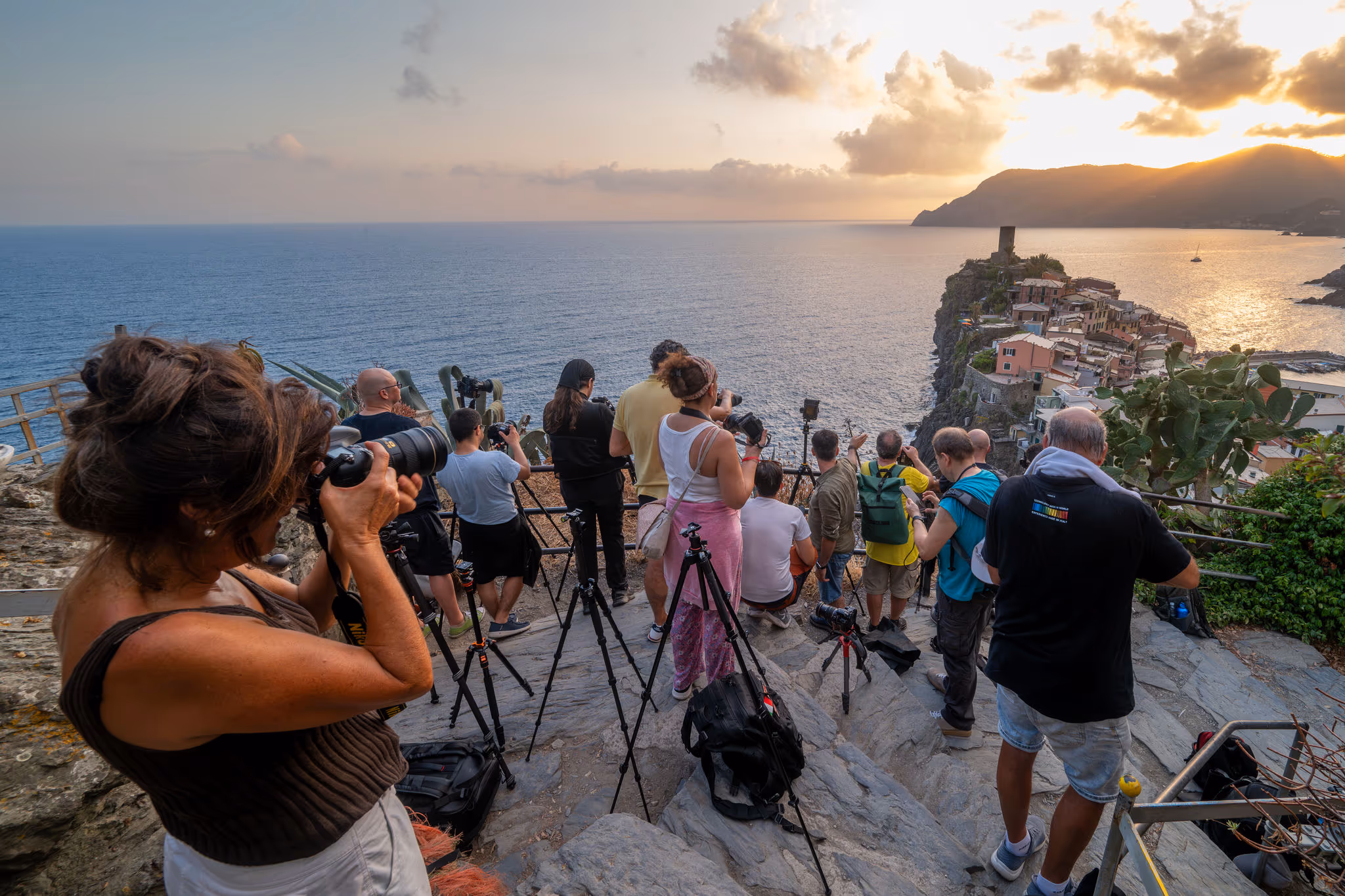 Fotografi osservano il tramonto dalla scogliera