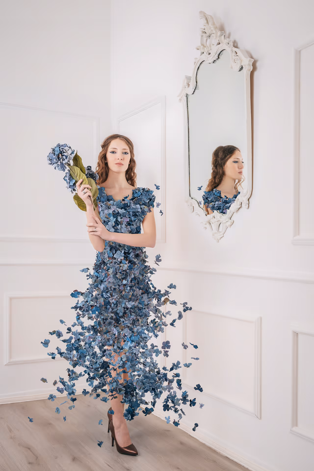 Modella in abito blu floreale davanti a uno specchio