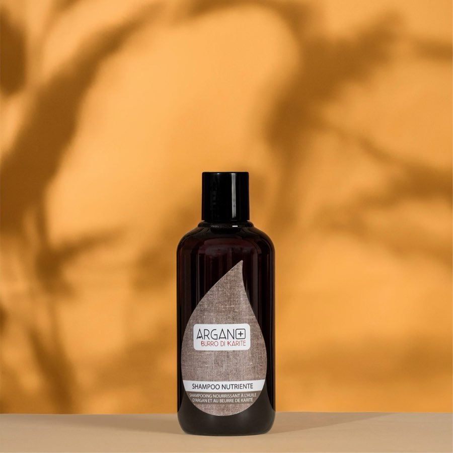 Flaconi cosmetici Argan Plus su fondo arancione