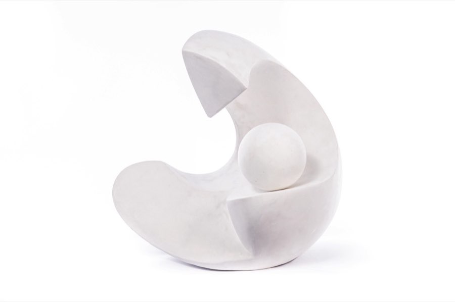 Scultura astratta bianca con sfera su fondo chiaro