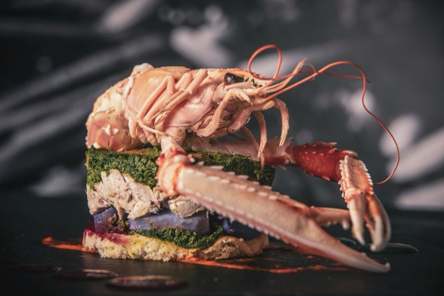 Astice e verdure impiattati in una composizione gourmet