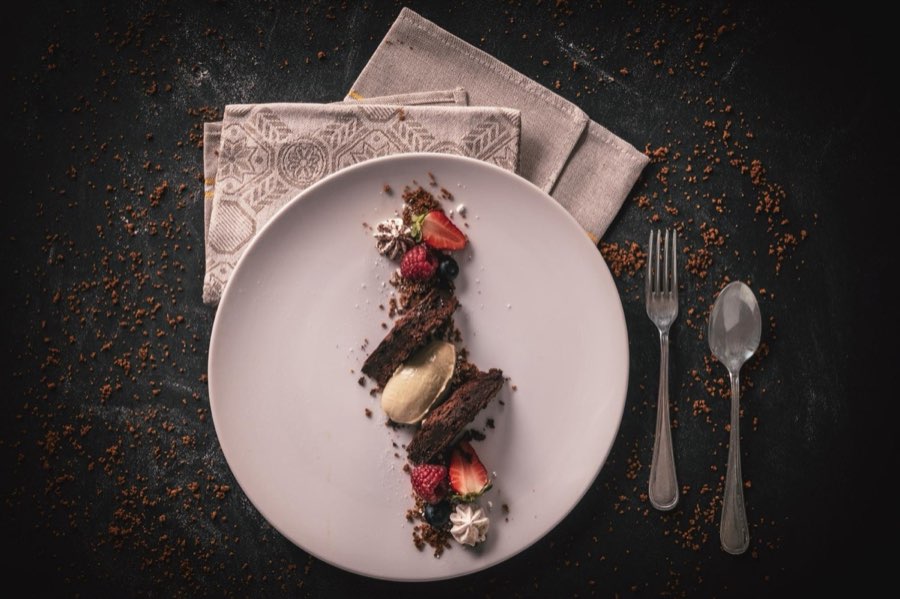 Dessert al cioccolato con frutti rossi su piatto chiaro