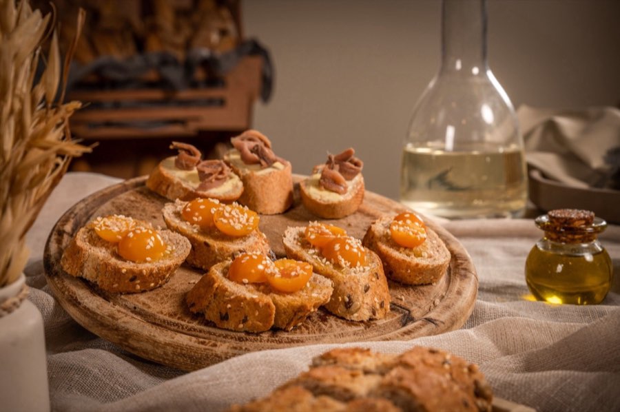 Crostini con pomodorini e semi su tagliere di legno