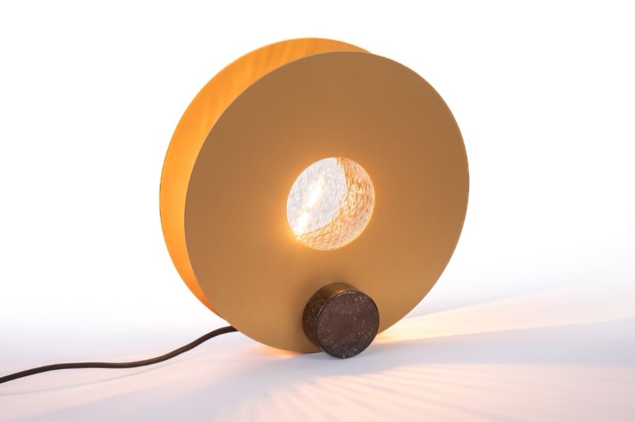 Lampada circolare arancione accesa su fondo chiaro
